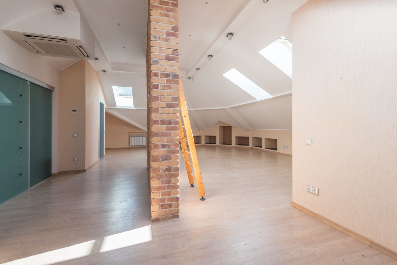 A bright, boarded loft space reached by a neat ladder